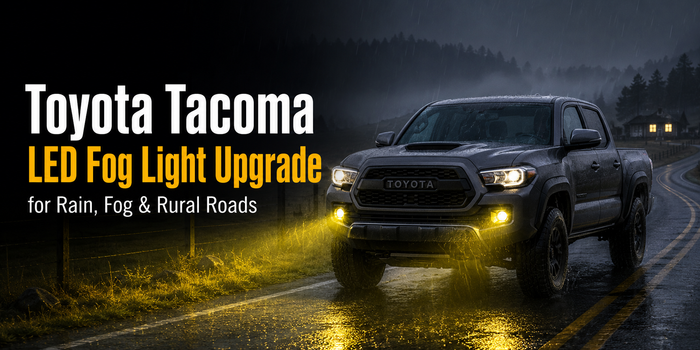 Toyota Tacoma with yellow LED fog lights driving on a rainy rural road at night