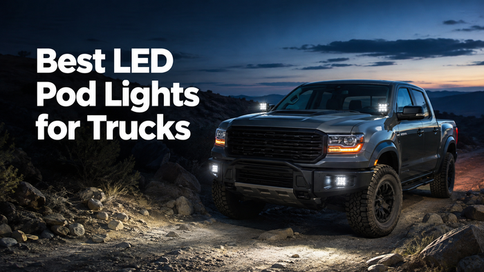 Off-road truck equipped with LED pod lights on the A-pillars and front bumper driving on a rocky trail at dusk.