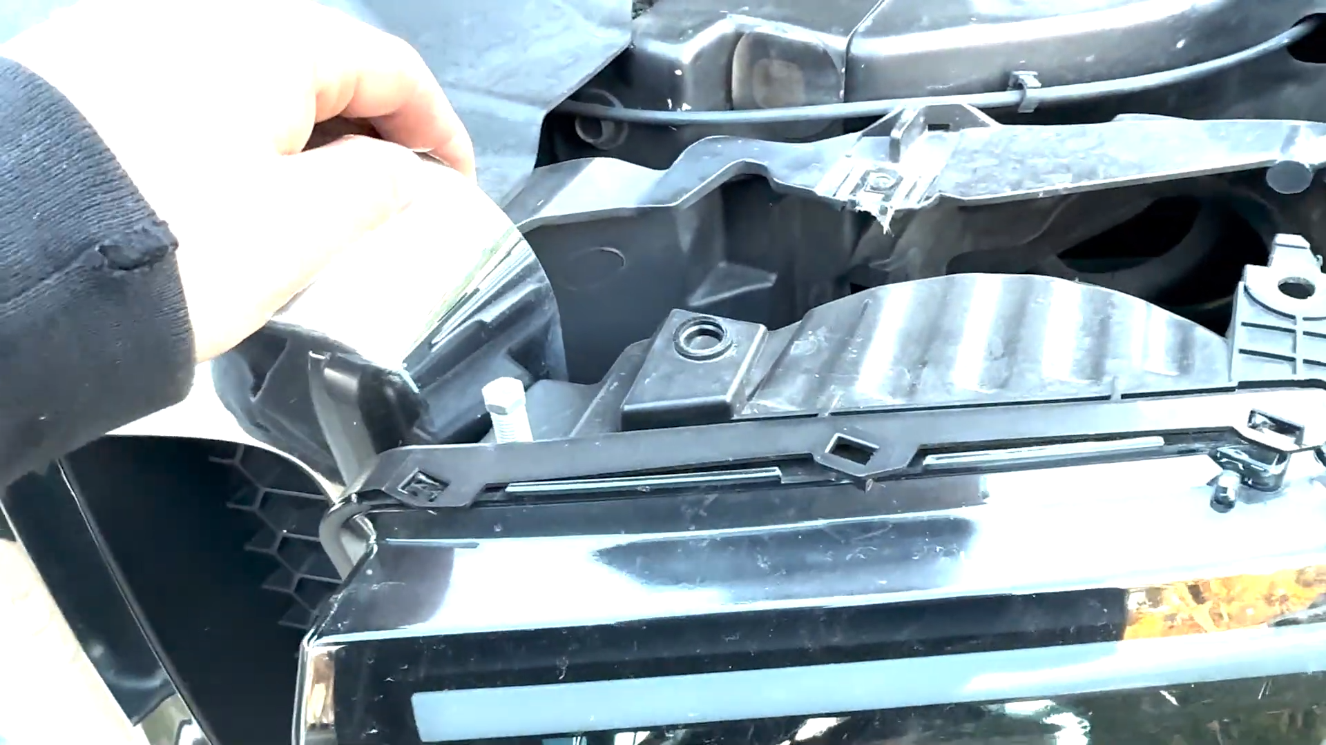 Pull the front grille forward and shift it slightly to create enough working space